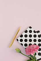 polka dot notebook, pink carnation, and gold pen 