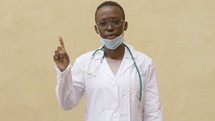 a healthcare worker in a mask giving a thumbs up 