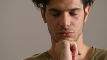 Man resting his chin on his hand and looking into camera.