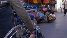 a man in a wheelchair shopping at an outdoor market 