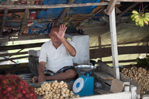vendor at a market selling potatoes 