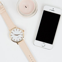 watch, candle, and iPhone on a white background 