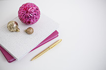 gold and fuchsia ornaments on journals 