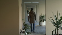 blind man walking in a hallway 