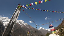 Tibetan prayer flags blowing in wind with Himalaya Mountains in background
