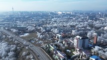 Aerial View of Cars Driving Through Road Along The Buildings With Ice-covered Trees In Winter In Galati City, Romania.	