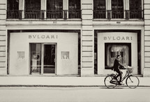 man riding a bike in front of perfume store