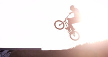 BMX rider extreme bikes does 360 spin over dirt jump