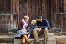 family sitting together on steps outdoors