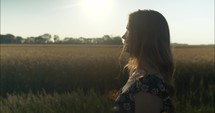 Sun light shine son woman on farm watching sunset.