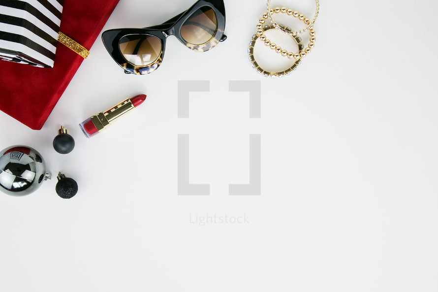 lipstick, bracelets, sunglasses, presents, ornaments, Christmas, red, gold, black, white 