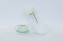 vase of flowers, tea pot, and cup of tea