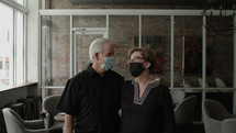 senior couple at a restaurant wearing face masks 
