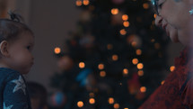 a toddler in front of a Christmas tree