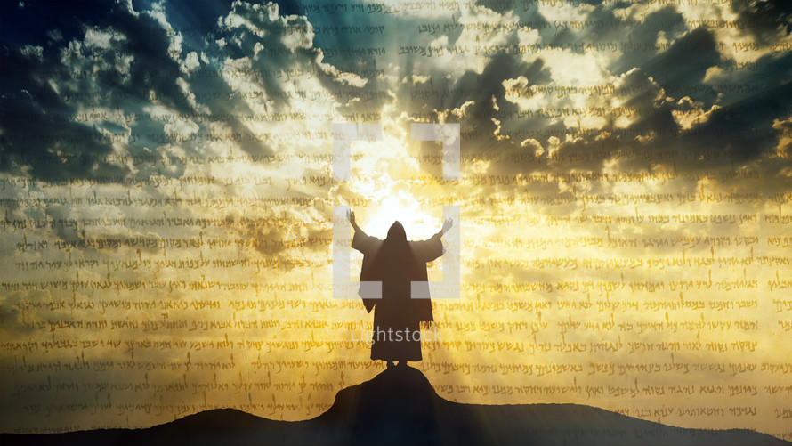 Silhouette of Jesus praying on a hill crest with sun rays and mystic clouds behind Him.

