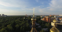 Aerial cityscape at sunset with golden dome of Orthodox church