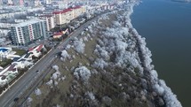 Winter Trees And City Buildings Along Danube River In Galati, Romania. aerial tilt-up shot	
