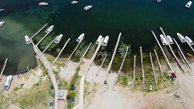 Aerial shot drone hover over boat docks as waves gently flow under boats