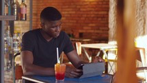 a young man using a tablet in a cafe 