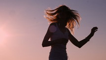 Woman dancing during sunset.