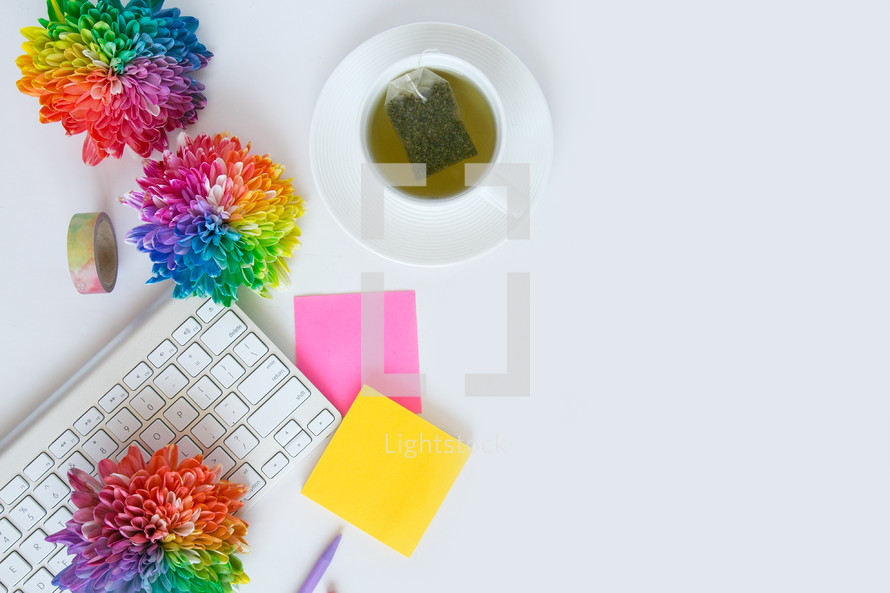 tea bag, notepad, tea, desk, rainbow, flowers, computer, keyboard, pen, gold,  journal, white background 