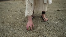 The feet of Jesus Christ, bible prophet or religious man in white tunic and sandals in the Jerusalem wilderness. 