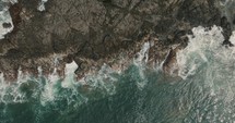 Top down View Of Ocean Waves Crashing On Rocky Shore Of Beach In Guanacaste, Costa Rica - aerial drone shot
