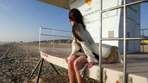 Beautiful Girl sitting on Lifeguard station on beach- Closeup3 