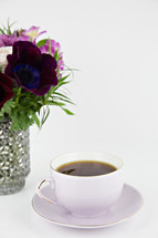 purple flower arrangement and tea cup