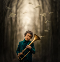 a boy holding a trumpet with paper airplanes floating from it 