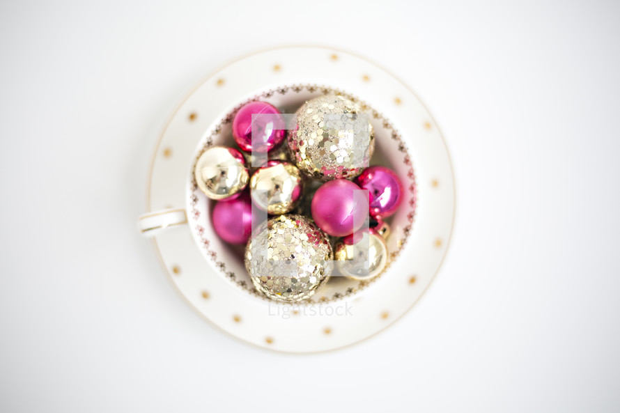 gold and fuchsia ornaments in a bowl 
