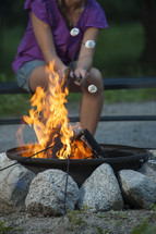woman roasting marshmallows over a fire 