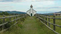 country church with a path lined by a fence 