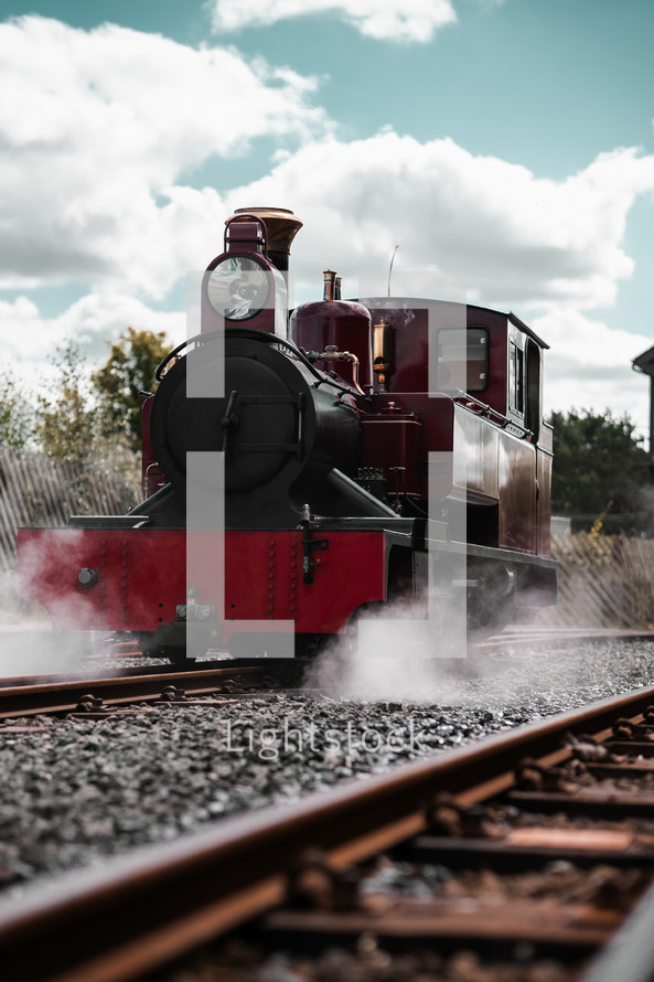 Steam train on a railway track, coal powered steam engine locomotive