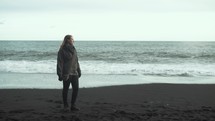 a woman standing on a beach in Iceland 