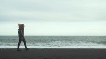 a woman walking on a beach in Iceland 