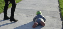 Toddler walking falls down on sidewalk