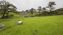 Ruins Of Stone House Stand Tall Above Dartmoor Grass Land