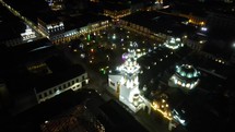 Aerial shot drone flies from west of main square in downtown Quito at night