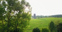 Sun glare reveal of a silo on a rural farm.