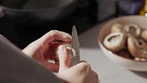 Woman's Hand Removing Stem Of Mushroom Then Placed In The Bowl. - close up shot