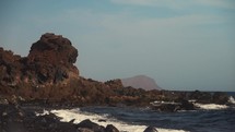 Waves crashing along a rocky beach shore in the Canary Islands.