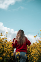 Freedom in nature, girl walking in a field, yellow rapeseed blue sky landscape photo