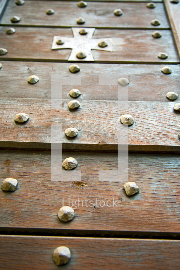 brass cross on a wood door 