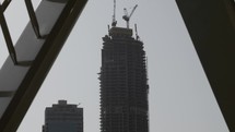 Skyscraper, buildings in Dubai under construction with cranes on the top.