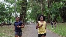 Tired male friends running in park together, urban healthy lifestyle, sports. Motivate tired friend to lose weight