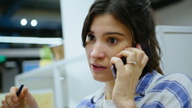 Young Woman Having Business Talk on Phone at Office Cubicle
