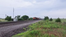 Freight train over railroad tracks coming into the country.