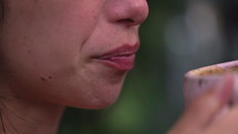 Woman licking lips after sipping coffee from cup - extreme close up