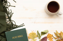mug, fall leaves on a green scarf and Holy Bible 